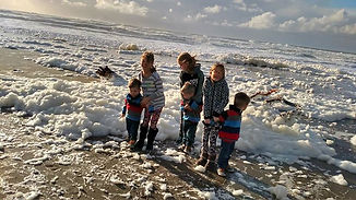 Family with young children standing by the shore