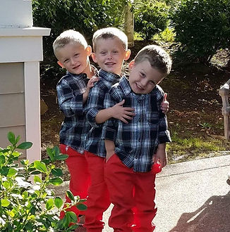 Three young boys standing together outdoors
