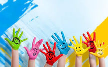 Hands raised together with colorful paint